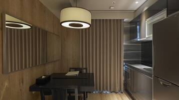 A modern kitchen with a built-in refrigerator, a dining area with a table and chairs, and a pendant light fixture.