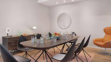 Un comedor moderno con una mesa redonda, sillas negras y un aparador de madera.
