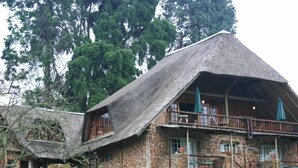 Un bâtiment en pierre avec un toit de chaume et un balcon.