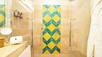 Une salle de bain moderne avec une douche à parois de verre, un miroir et un porte-serviettes.