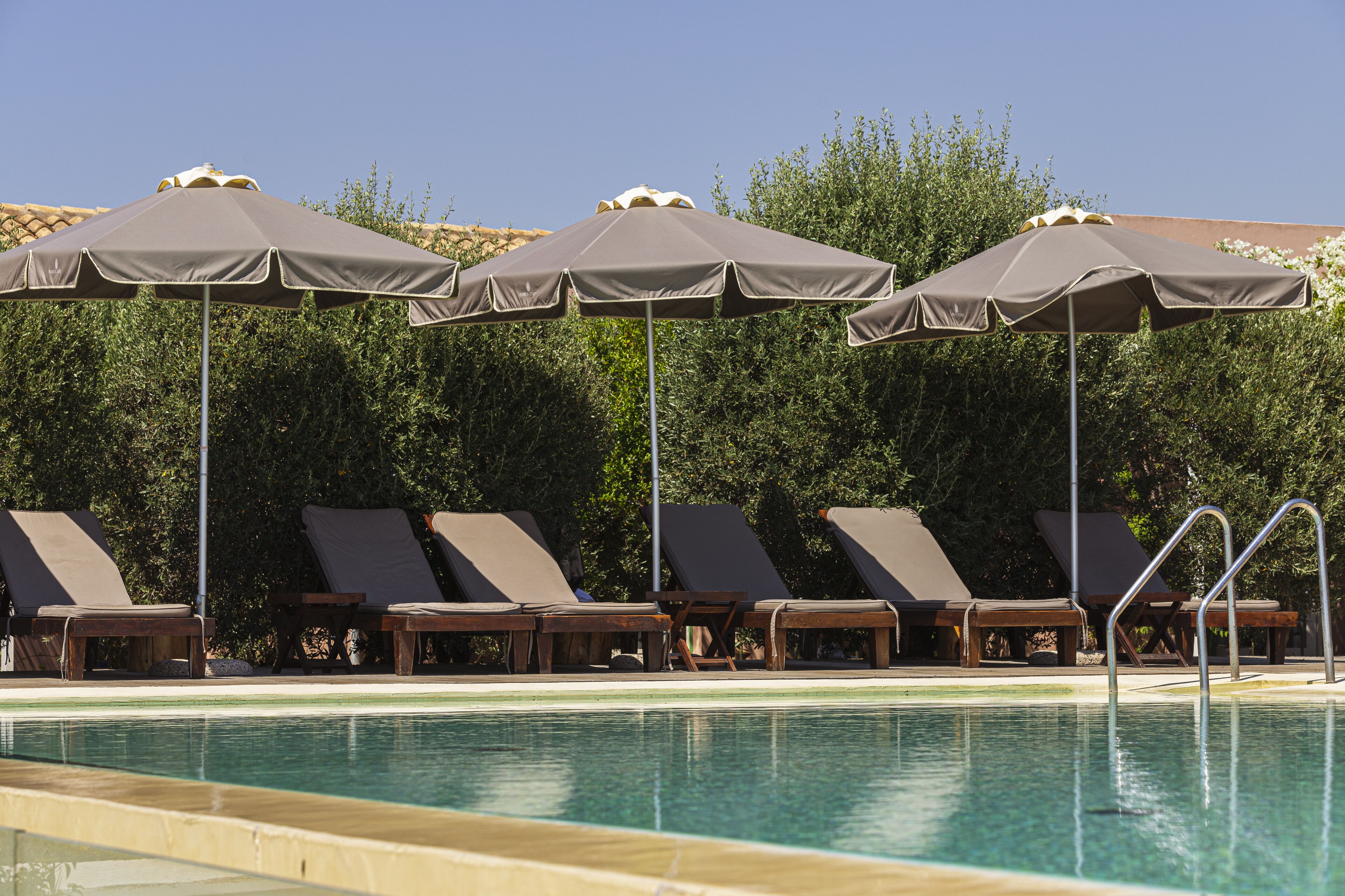 A poolside area with lounge chairs and umbrellas.