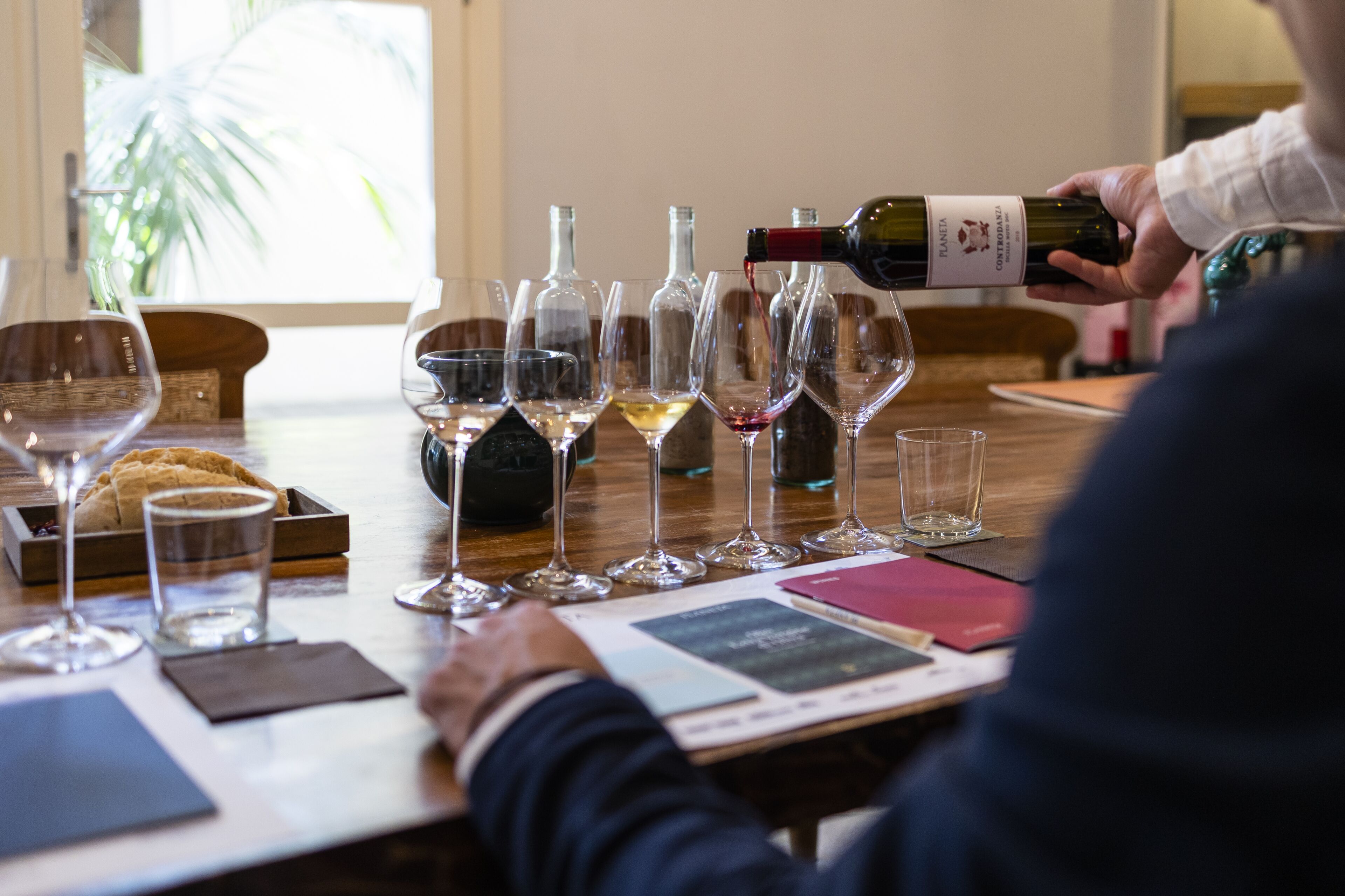 A wine tasting event with several wine glasses and bottles on a table.