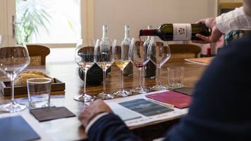 A wine tasting event with several wine glasses and bottles on a table.