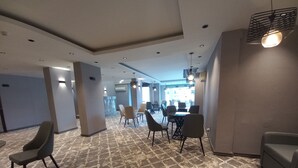 A spacious conference room with a patterned carpet, modern furniture, and recessed lighting.