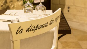 Una mesa con un cartel que dice "la dispensa dei saponi" y, al fondo, una pared de piedra y un edificio.