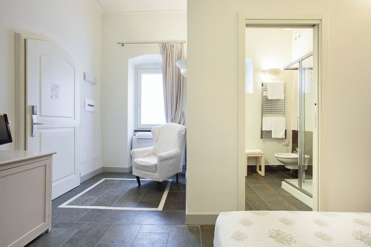 A bedroom with a bed, a bedside table, and a nightstand.
