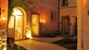 Un edificio de piedra con puertas arqueadas y un patio empedrado.