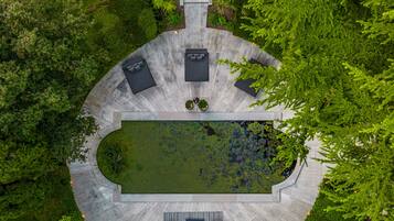 Relax by the central pool surrounded by lush greenery and seating areas.