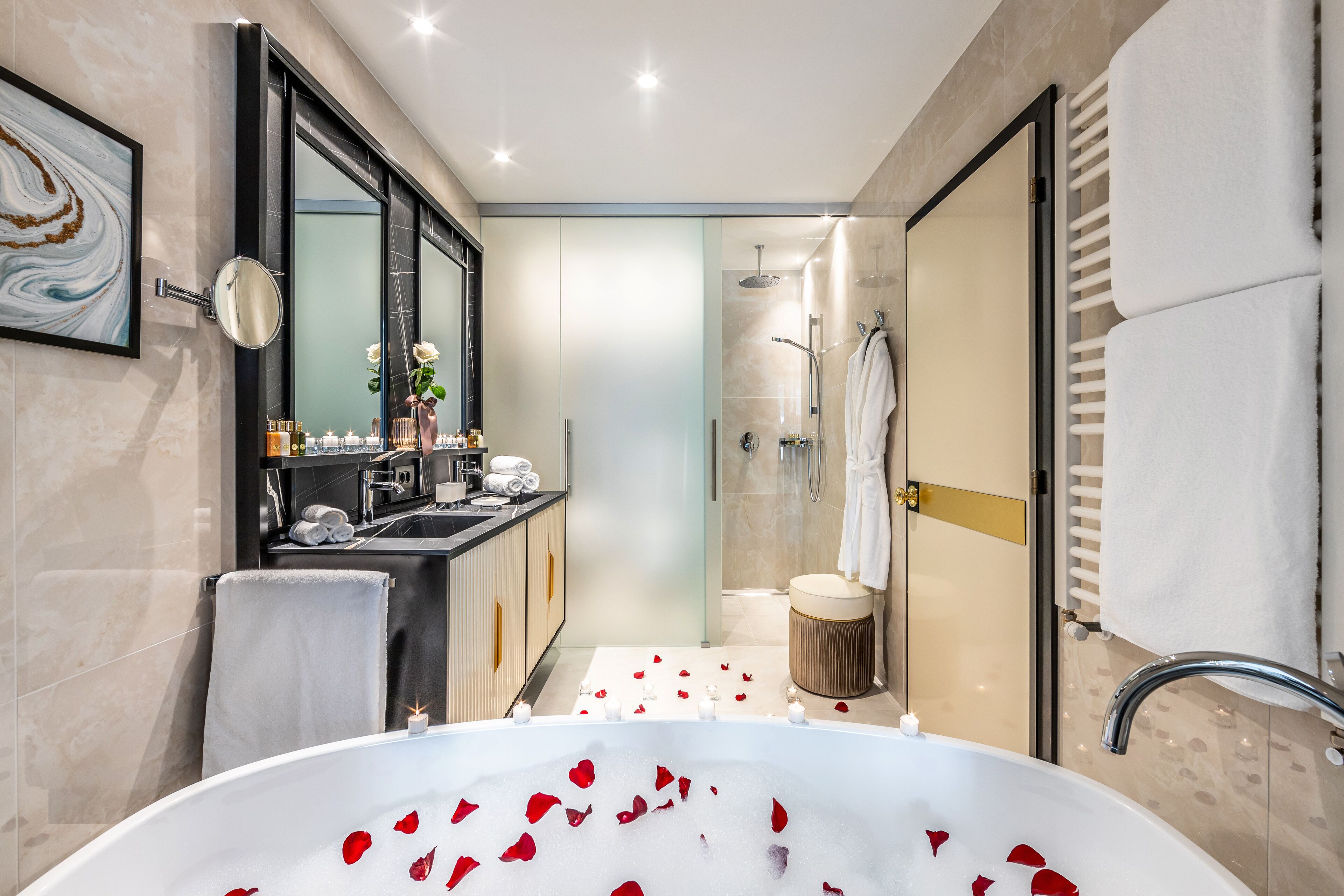 A modern bathroom with a large bathtub, a shower, and a vanity with a mirror.