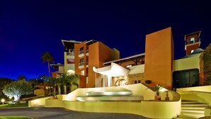 A modern hotel with a curved entrance, a central water feature, and multiple balconies. - Four Seasons Vilamoura (Loulé)