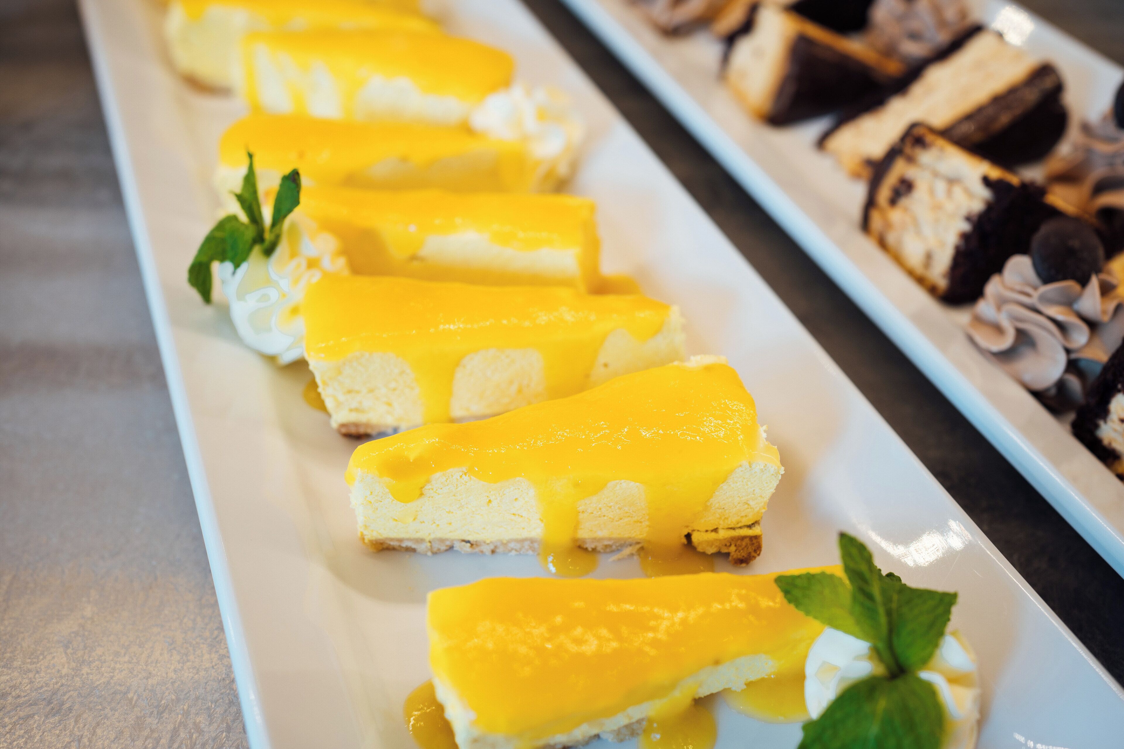 A dessert tray with cheesecake slices and other pastries.