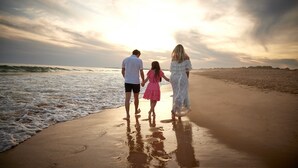 A family walking on a beach with the ocean in the background. - Four Seasons Vilamoura (Loulé)
