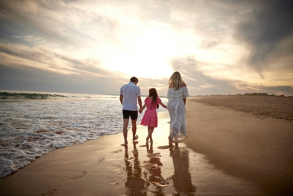 A family walking on a beach with the ocean in the background. - Four Seasons Vilamoura (Loulé)