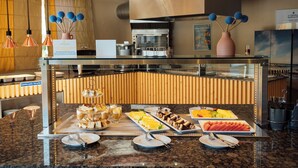 A buffet setup with various food items and a sign indicating a special offer. - Four Seasons Vilamoura (Loulé)