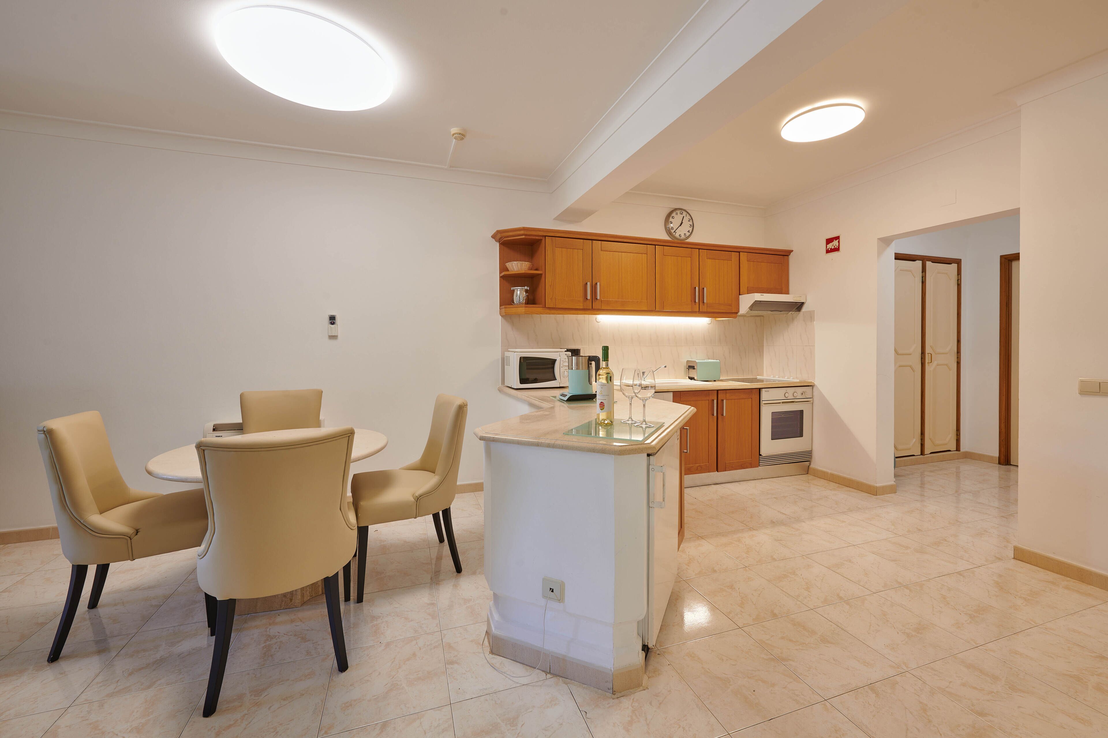Cocina moderna con una isla central, armarios de madera y un microondas.