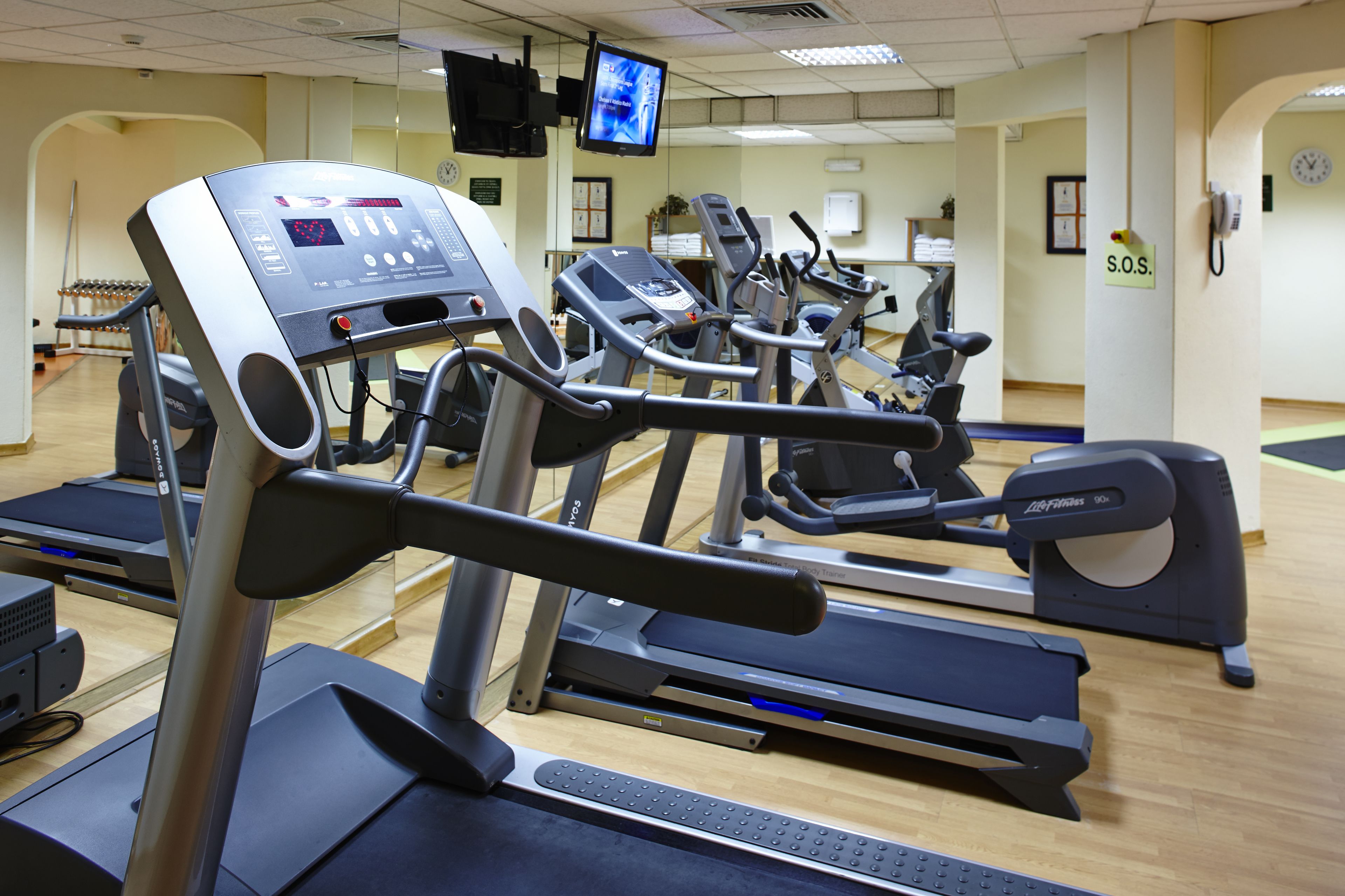 A gym with multiple treadmills, stationary bikes, and a rowing machine.