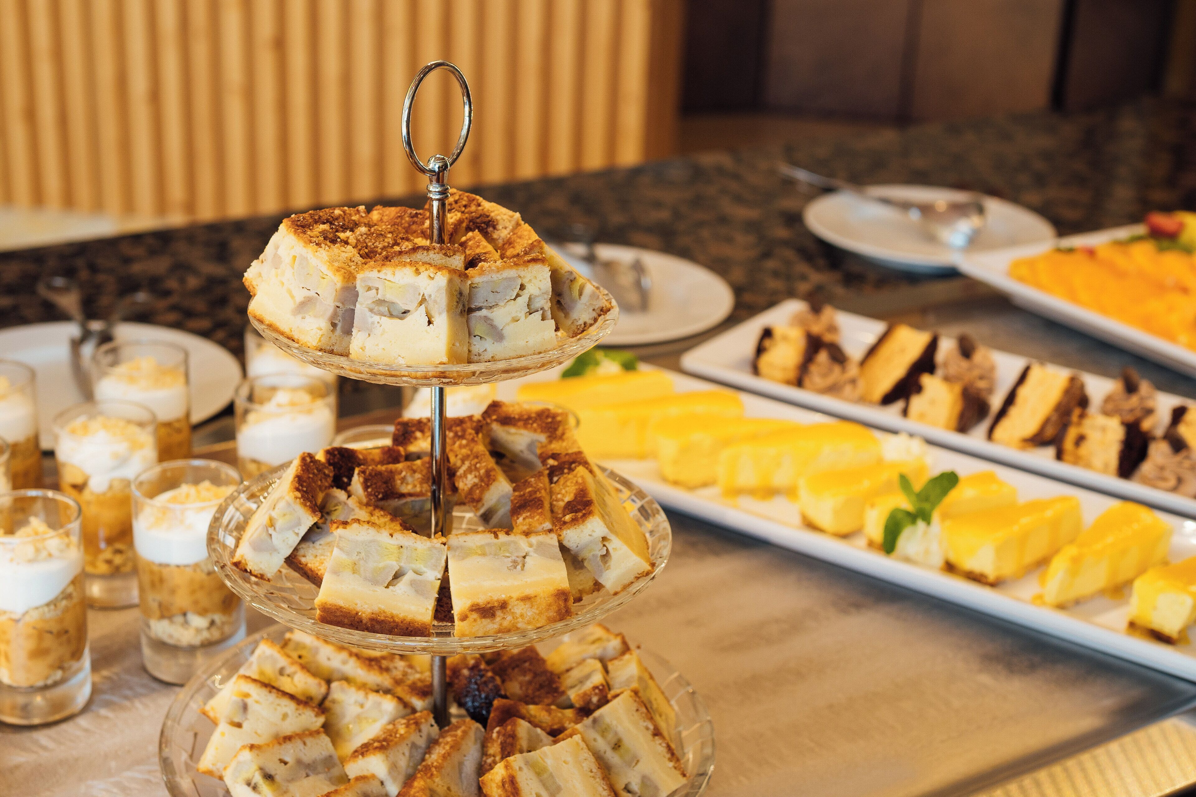 A buffet with various desserts including cakes and fruit.