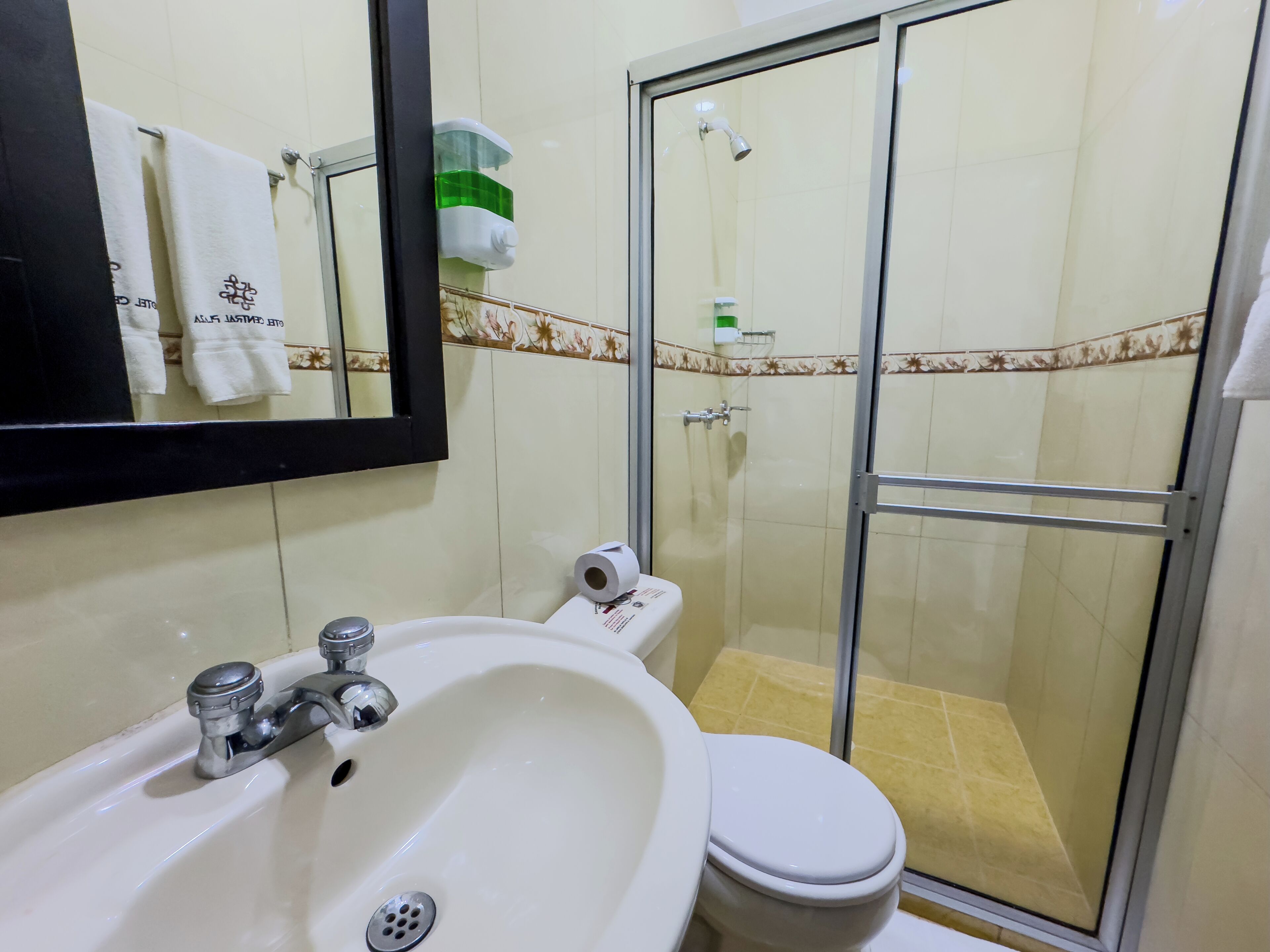 A bathroom with a sink, toilet, and glass-enclosed shower.