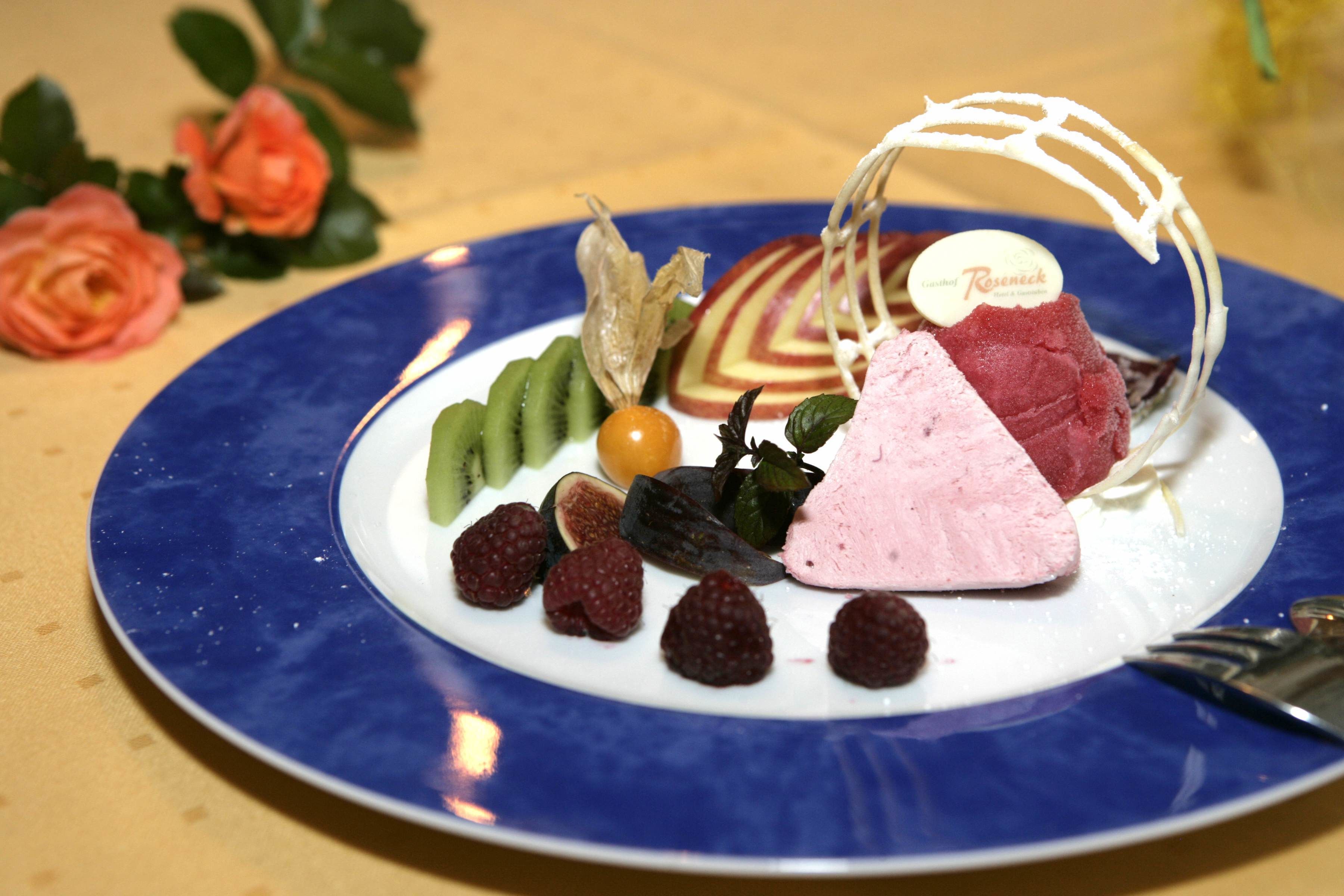 A dessert plate with various fruits and a cake, accompanied by a fork.