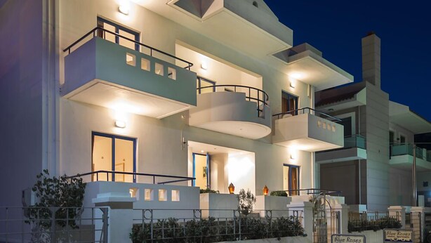 A multi-story hotel with balconies, a central courtyard, and a sign indicating 'Blue Roses'. - Blue Roses (Rhodes)