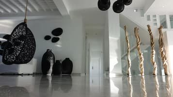A modern interior with a reflective floor, black decorative items, and a white ceiling.