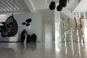 A modern interior with a reflective floor, black decorative items, and a white ceiling.