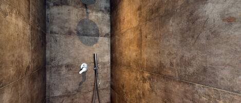 A modern shower with a handheld showerhead and a wall-mounted control panel.