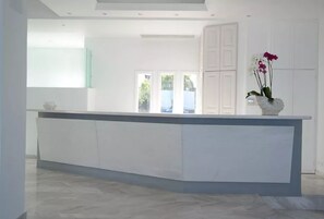 A modern kitchen with a central island, white cabinetry, and a view to the outdoors.