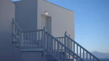 Un edificio moderno con fachada blanca, una escalera con barandillas blancas y una puerta.