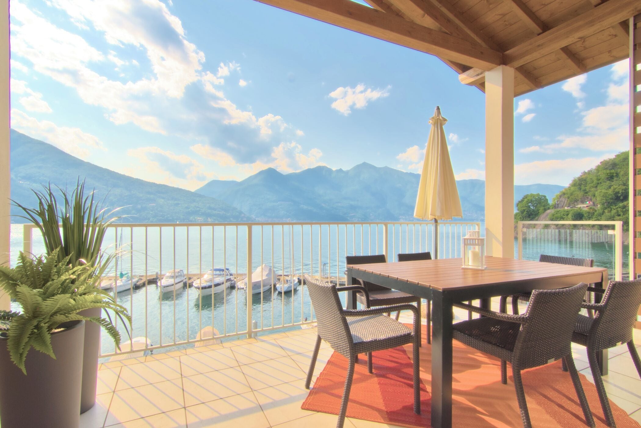 A terrace with a view of mountains and a marina.