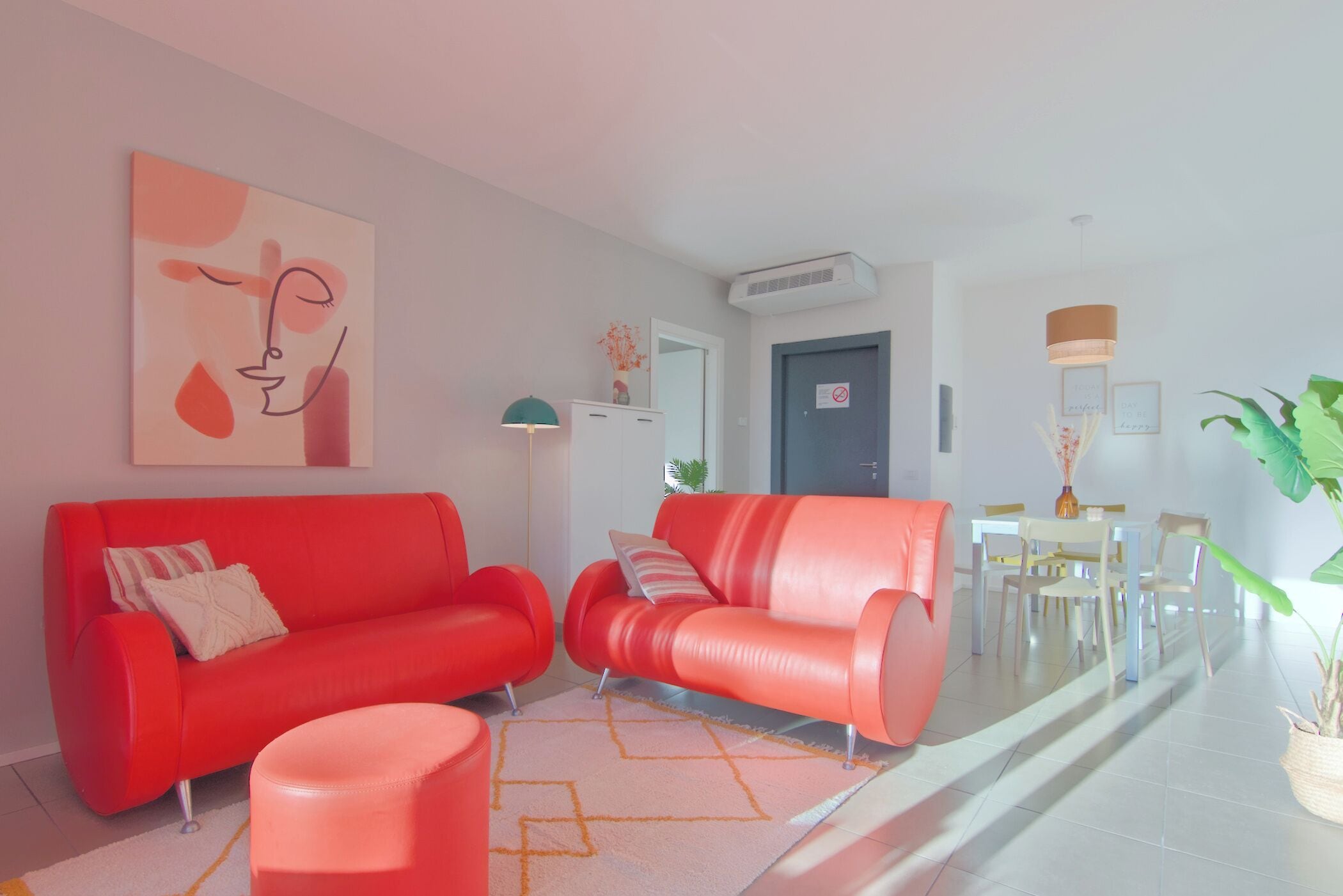 A modern living room with a red sofa set, a coffee table, and a dining area with a table and chairs.