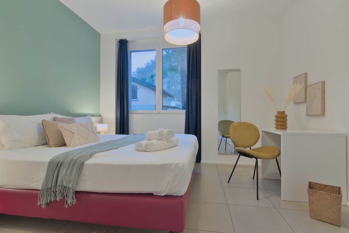 A modern bedroom with a bed, a desk, and a chair.