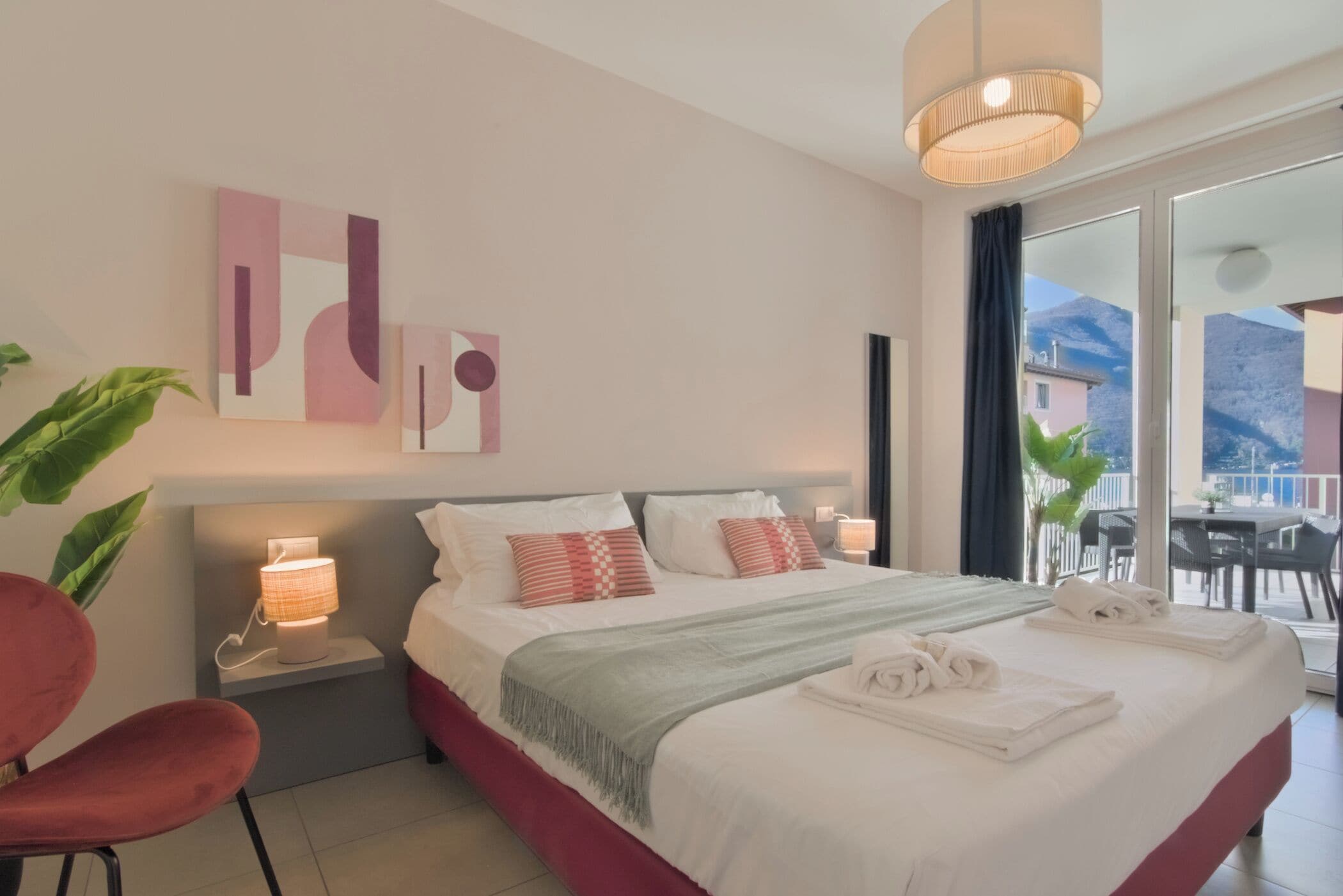 A modern hotel room with a large bed, bedside lamps, and a view of the outdoors.