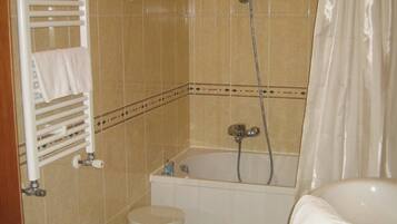 Un bagno con una vasca, un water, un bidet e un porta asciugamani.