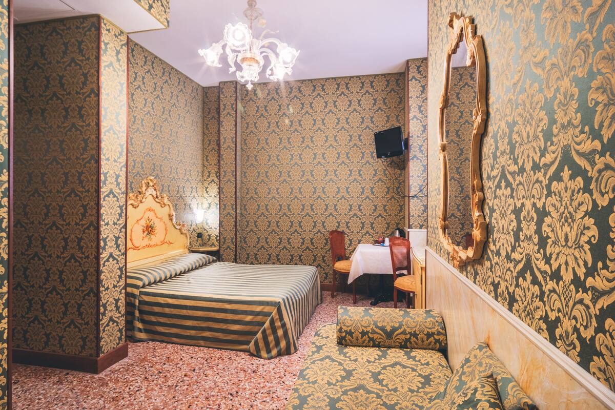 Una habitación con una cama, una mesa y una silla.