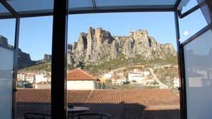 A balcony with a view of a mountain and buildings. - Alexiou Hotel (Kalabaka)