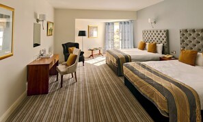 A hotel room with two beds, a desk, a chair, and a small table. - Brook Lodge Boutique Hotel (Killarney)