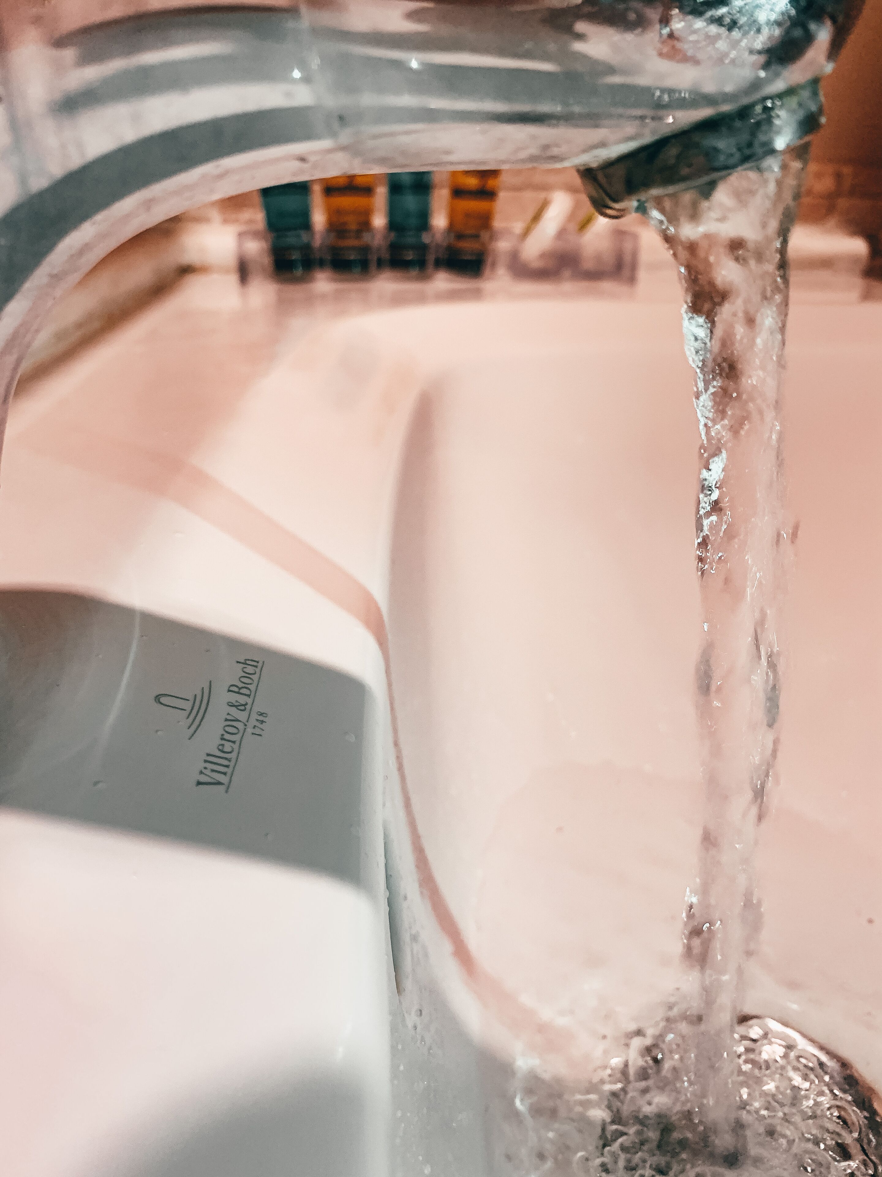 A clear water stream from a tap with a visible brand name.