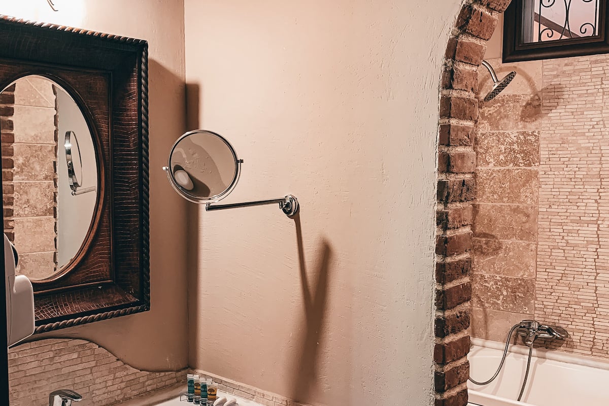 A bathroom with a white sink, a mirror, a towel rack, and a bathtub.