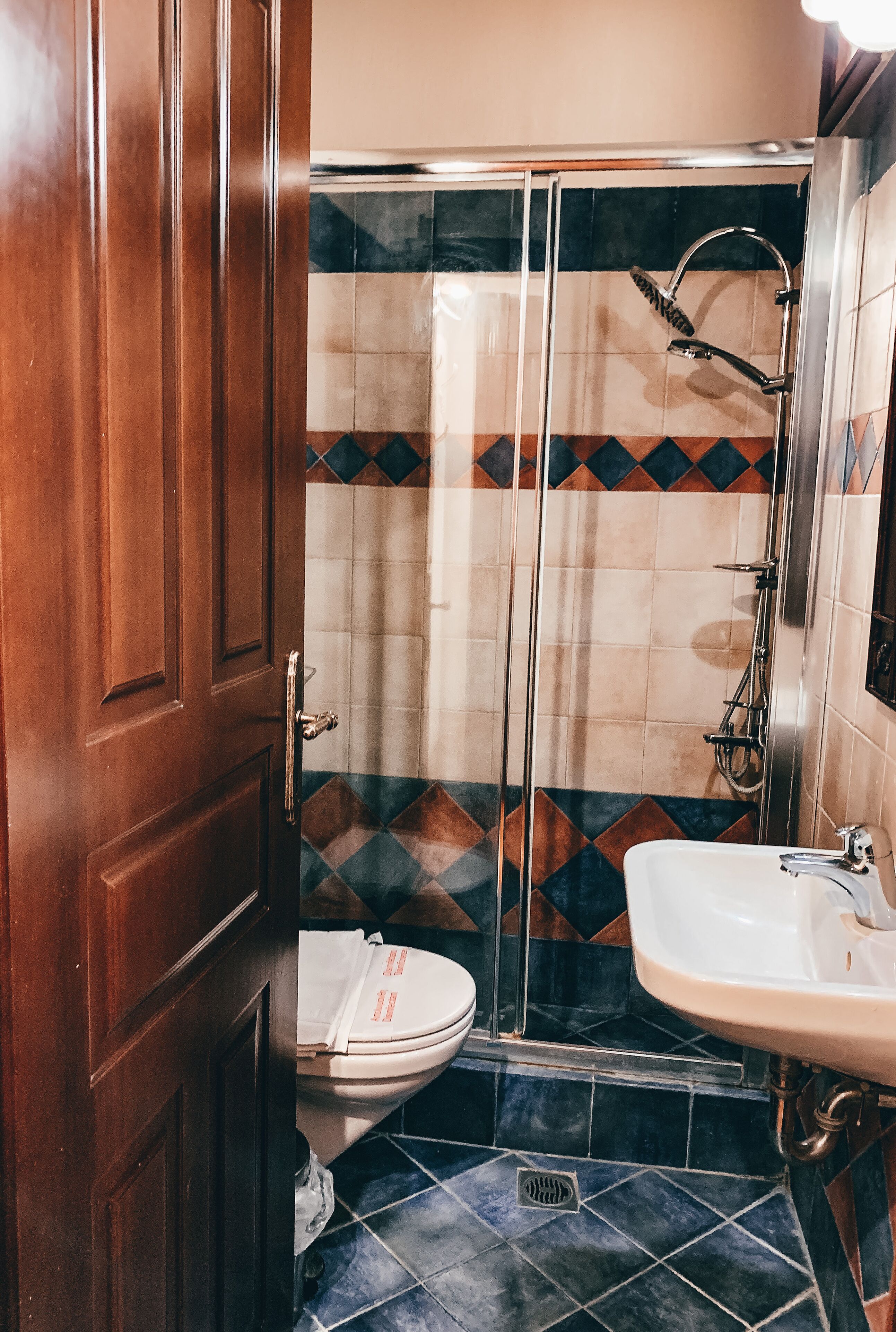 A bathroom with a toilet, a shower, and a sink.