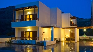 A modern two-story house with a balcony, a covered outdoor seating area, and a pool. - Syia Hotel (Kantanos-Selino)