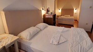 A bedroom with a bed, a nightstand, a table, and a mirror. - Diporto (Chania)