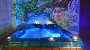 A hot tub with a waterfall mural in the background. - Rezydencja Bialy Jar (Karpacz)