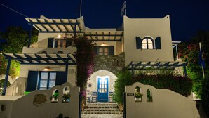A white building with a blue door and steps leading up to it.