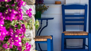 A blue chair and table set against a white wall with a purple wreath.