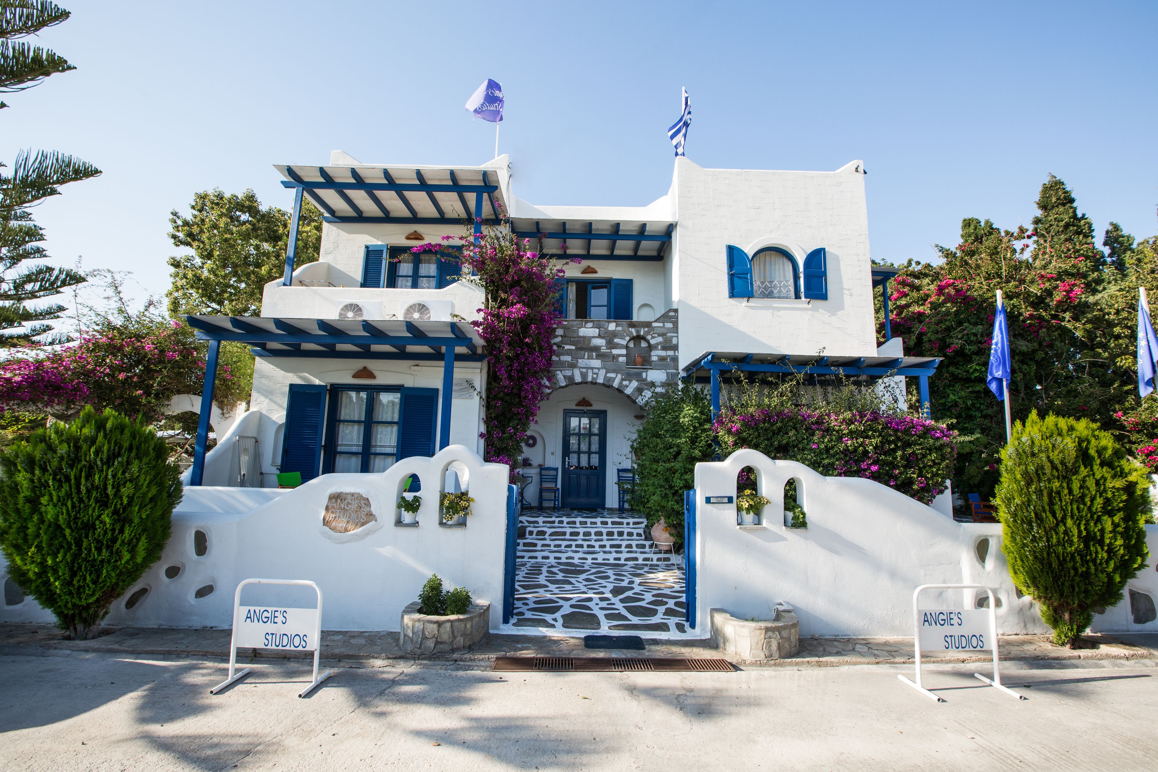 Un bâtiment blanc agrémenté de touches de bleu, avec une enseigne indiquant « Angie’s Studios ».