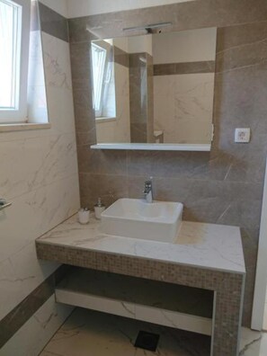 A bathroom with a white sink, a mirror, and a window. - Sea Apartments Slano (Dubrovacko Primorje)