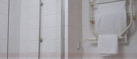 A bathroom with a shower, a toilet, and a towel rack.