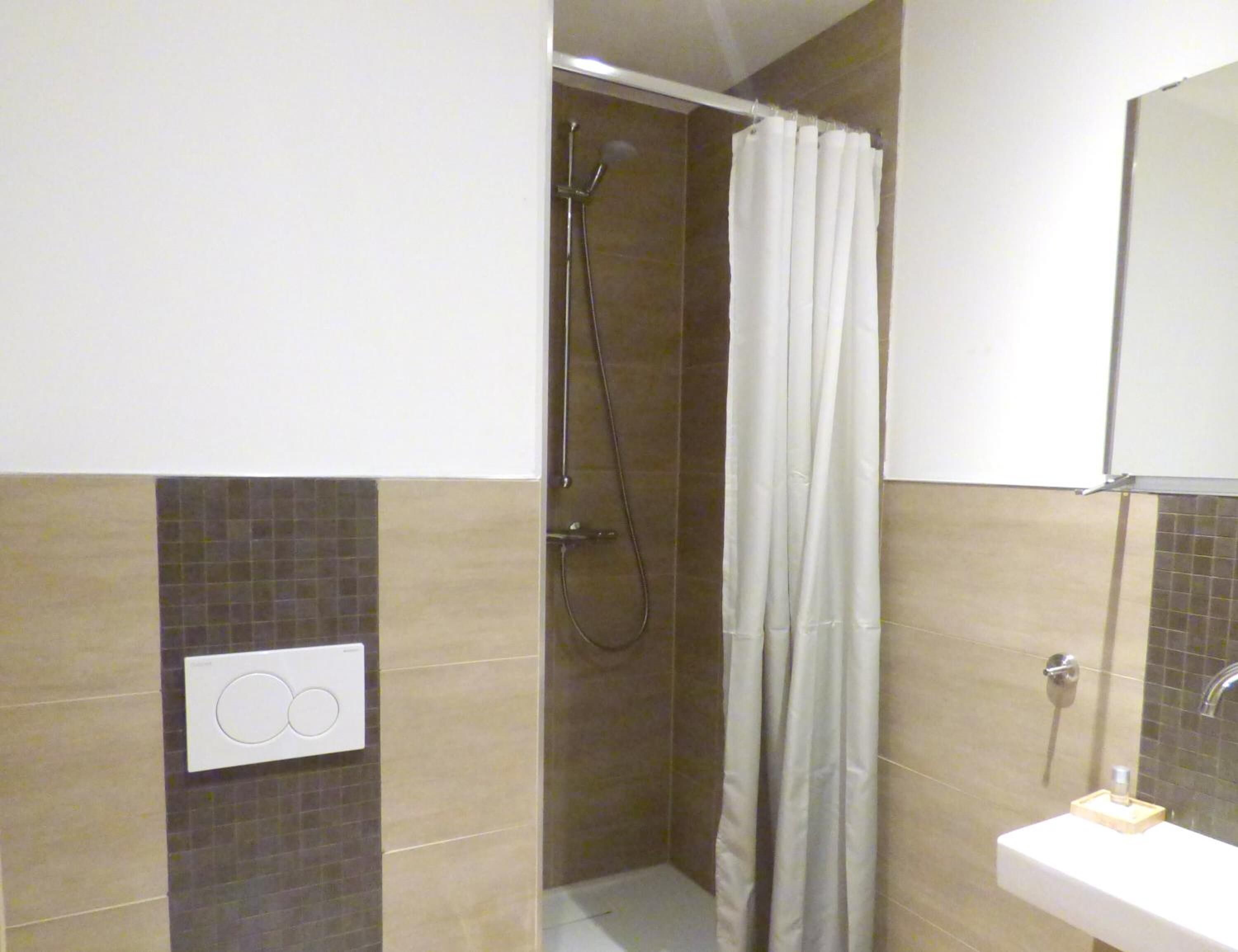 Un baño con ducha, inodoro y lavabo.