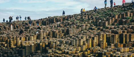 A large, ancient stone structure with visitors scattered across its surface.